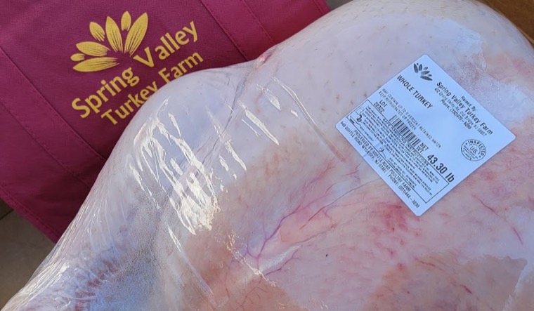 A whole Spring Valley turkey boxed for pick up beside branded Spring Valley Turkey Farm bags